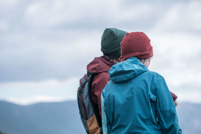 2 girls watching landscape in hiking clothes and winter hats