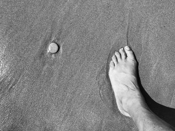 Low section of man standing on sand