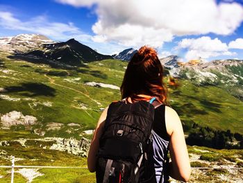 Rear view of hiker standing against mountain