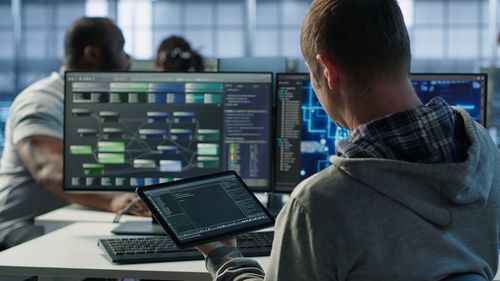 Rear view of man using laptop at office