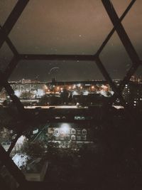 High angle view of illuminated buildings seen through window