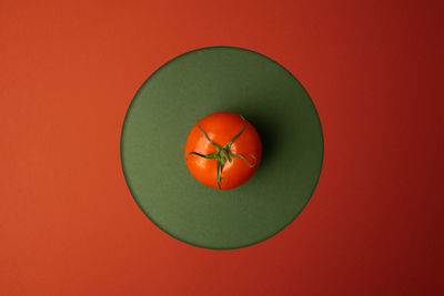 Directly above shot of orange fruit against red background