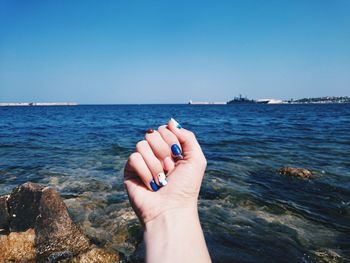 Human hand against sea