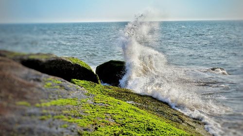 Scenic view of sea waves splashing on rocks