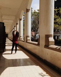 Rear view of woman standing in corridor 