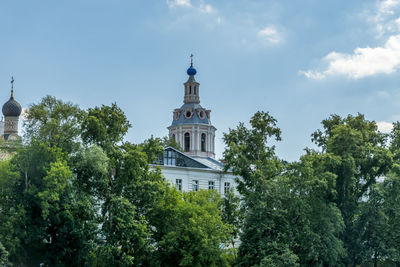 Low angle view of trees and building against sky