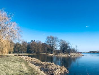 Scenic view of lake against clear blue sky