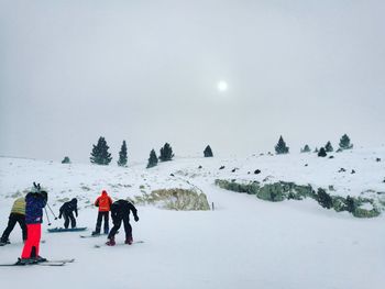 People skiing on snow against sky