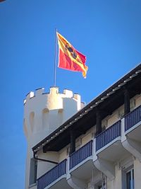 Low angle view of flag against clear blue sky