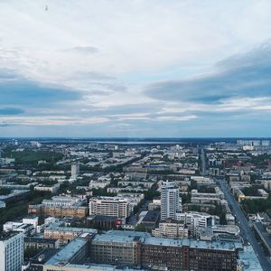 High angle view of city buildings against cloudy sky