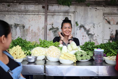 Portrait of smiling woman selling vegetable outdoors
