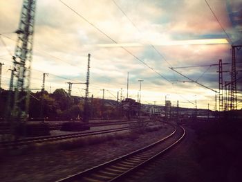 Railroad tracks against cloudy sky