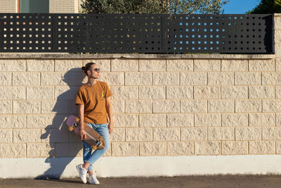 Full length of woman standing against wall