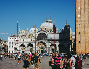 Group of people in front of building against clear sky