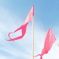 Low angle view of pink flags against sky