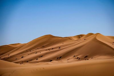 Scenic view of desert against clear blue sky