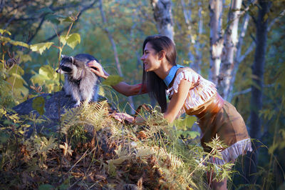 Full length of young woman feeding outdoors