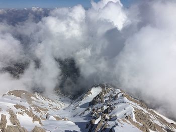 Scenic view of snow covered mountain against cloudy sky