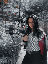 Portrait of woman standing against plants