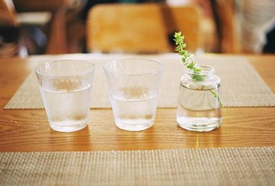 Drinking glasses and jar on wooden table