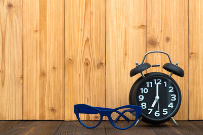Close-up of clock on wooden floor