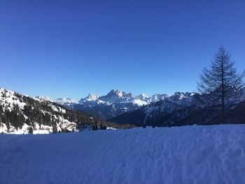 Scenic view of snowcapped mountains against clear blue sky