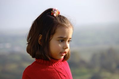 Portrait of girl looking away against sea