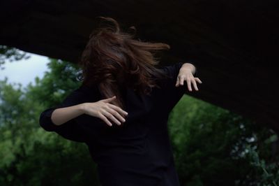 Woman tossing hair while standing outdoors