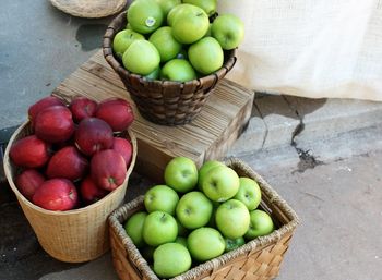 High angle view of apples in baskets for sale at street market