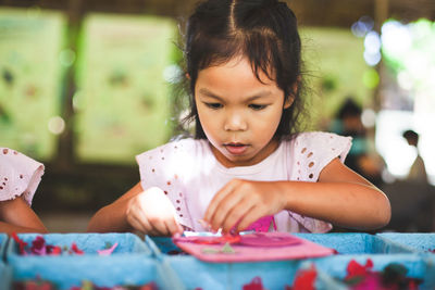 Close-up of cute girl making artwork at workshop