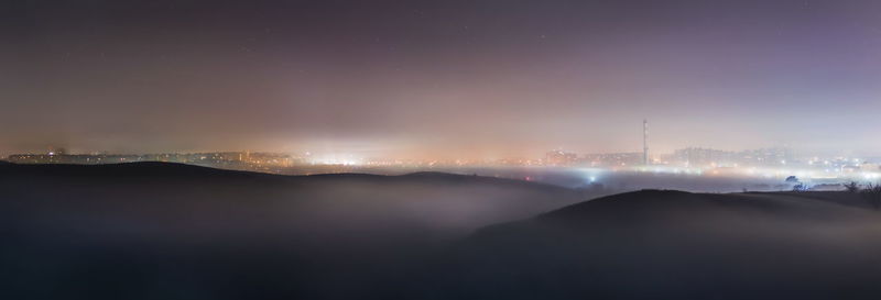 Illuminated cityscape against sky at night