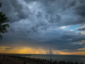 Scenic view of sea against dramatic sky during sunset