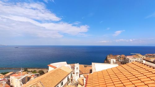 High angle view of townscape by sea against sky