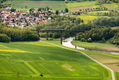 High angle view of trees and buildings on field