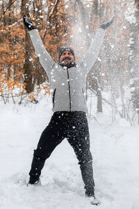Man throws snowballs in the snowy forest