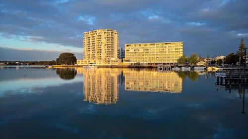 Reflection of building in lake against sky