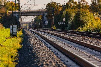 Straight track and rails with a bridge and track bed with ballast and electric overhead lines