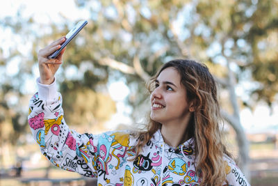 Portrait of young woman using smart phone outdoors