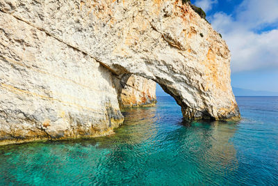 Rock formation in sea against sky