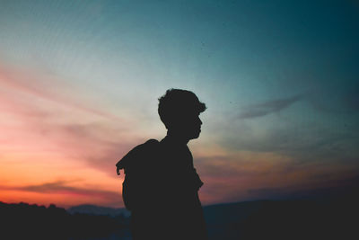 Silhouette woman standing against sky during sunset