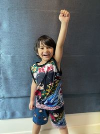 Portrait of smiling boy standing against wall