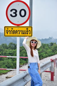Full length of young woman standing on road