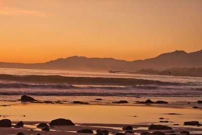 Scenic view of sea against orange sky