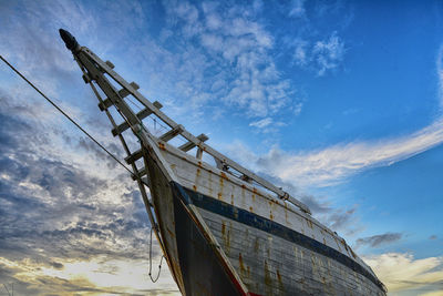 Low angle view of ship against cloudy sky