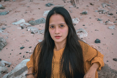 Portrait of young woman standing at beach