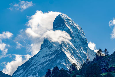 Low angle view of snowcapped mountains against sky