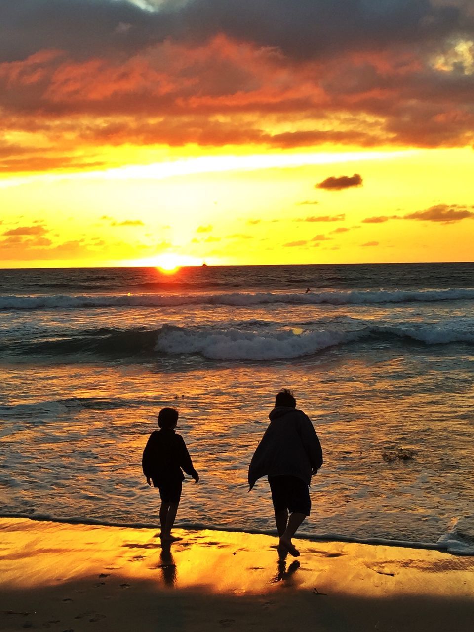 sunset, sea, horizon over water, beach, water, shore, orange color, sky, leisure activity, scenics, beauty in nature, silhouette, lifestyles, sun, vacations, tranquil scene, men, idyllic, standing