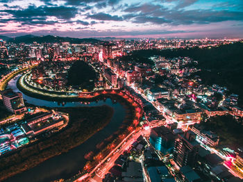 High angle view of city lit up at night