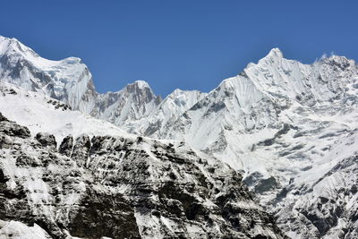 Scenic view of snowcapped mountains against clear blue sky