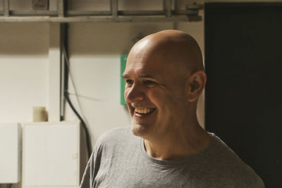 Close-up of smiling man looking away at factory